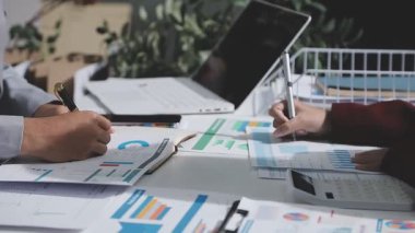 Yatırım sonuçlarını kontrol eden Asyalı erkek finans görevlisi veya muhasebeci, mali bütçe analizi sonuçları özetlemeyi ve denetim konsepti ve yatırım sonuçlarını toplantıya rapor etmeyi planlıyor.