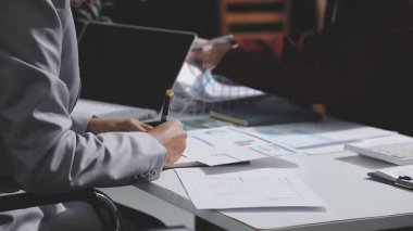 Yatırım sonuçlarını kontrol eden Asyalı erkek finans görevlisi veya muhasebeci, mali bütçe analizi sonuçları özetlemeyi ve denetim konsepti ve yatırım sonuçlarını toplantıya rapor etmeyi planlıyor.