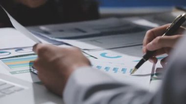 Yatırım sonuçlarını kontrol eden Asyalı erkek finans görevlisi veya muhasebeci, mali bütçe analizi sonuçları özetlemeyi ve denetim konsepti ve yatırım sonuçlarını toplantıya rapor etmeyi planlıyor.