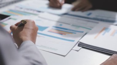 Yatırım sonuçlarını kontrol eden Asyalı erkek finans görevlisi veya muhasebeci, mali bütçe analizi sonuçları özetlemeyi ve denetim konsepti ve yatırım sonuçlarını toplantıya rapor etmeyi planlıyor.