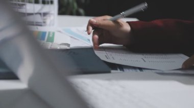 Yatırım sonuçlarını kontrol eden Asyalı erkek finans görevlisi veya muhasebeci, mali bütçe analizi sonuçları özetlemeyi ve denetim konsepti ve yatırım sonuçlarını toplantıya rapor etmeyi planlıyor.