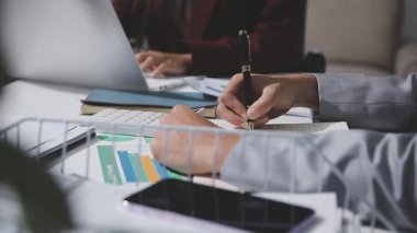 Yatırım sonuçlarını kontrol eden Asyalı erkek finans görevlisi veya muhasebeci, mali bütçe analizi sonuçları özetlemeyi ve denetim konsepti ve yatırım sonuçlarını toplantıya rapor etmeyi planlıyor.