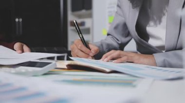 Yatırım sonuçlarını kontrol eden Asyalı erkek finans görevlisi veya muhasebeci, mali bütçe analizi sonuçları özetlemeyi ve denetim konsepti ve yatırım sonuçlarını toplantıya rapor etmeyi planlıyor.