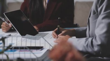 Yatırım sonuçlarını kontrol eden Asyalı erkek finans görevlisi veya muhasebeci, mali bütçe analizi sonuçları özetlemeyi ve denetim konsepti ve yatırım sonuçlarını toplantıya rapor etmeyi planlıyor.