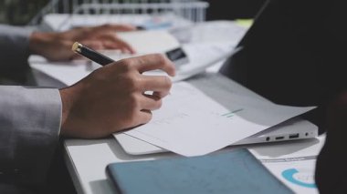 Yatırım sonuçlarını kontrol eden Asyalı erkek finans görevlisi veya muhasebeci, mali bütçe analizi sonuçları özetlemeyi ve denetim konsepti ve yatırım sonuçlarını toplantıya rapor etmeyi planlıyor.