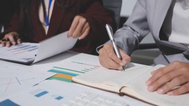 Yatırım sonuçlarını kontrol eden Asyalı erkek finans görevlisi veya muhasebeci, mali bütçe analizi sonuçları özetlemeyi ve denetim konsepti ve yatırım sonuçlarını toplantıya rapor etmeyi planlıyor.