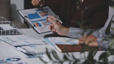 Yatırım sonuçlarını kontrol eden Asyalı erkek finans görevlisi veya muhasebeci, mali bütçe analizi sonuçları özetlemeyi ve denetim konsepti ve yatırım sonuçlarını toplantıya rapor etmeyi planlıyor.