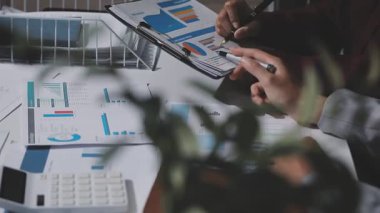 Yatırım sonuçlarını kontrol eden Asyalı erkek finans görevlisi veya muhasebeci, mali bütçe analizi sonuçları özetlemeyi ve denetim konsepti ve yatırım sonuçlarını toplantıya rapor etmeyi planlıyor.