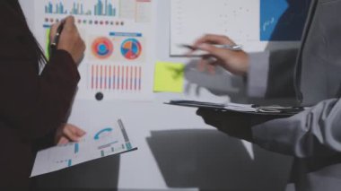 Yatırım sonuçlarını kontrol eden Asyalı erkek finans görevlisi veya muhasebeci, mali bütçe analizi sonuçları özetlemeyi ve denetim konsepti ve yatırım sonuçlarını toplantıya rapor etmeyi planlıyor.