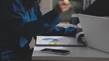 Yatırım sonuçlarını kontrol eden Asyalı erkek finans görevlisi veya muhasebeci, mali bütçe analizi sonuçları özetlemeyi ve denetim konsepti ve yatırım sonuçlarını toplantıya rapor etmeyi planlıyor.