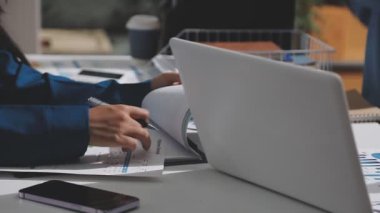 Yatırım sonuçlarını kontrol eden Asyalı erkek finans görevlisi veya muhasebeci, mali bütçe analizi sonuçları özetlemeyi ve denetim konsepti ve yatırım sonuçlarını toplantıya rapor etmeyi planlıyor.