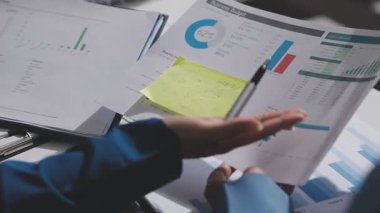 Yatırım sonuçlarını kontrol eden Asyalı erkek finans görevlisi veya muhasebeci, mali bütçe analizi sonuçları özetlemeyi ve denetim konsepti ve yatırım sonuçlarını toplantıya rapor etmeyi planlıyor.