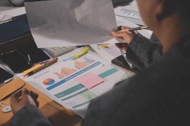 Tablet, akıllı telefon ve dizüstü bilgisayarlı iş belgeleri ve veri tartışan iki iş arkadaşı