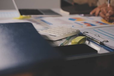 Tablet, akıllı telefon ve dizüstü bilgisayarlı iş belgeleri ve veri tartışan iki iş arkadaşı