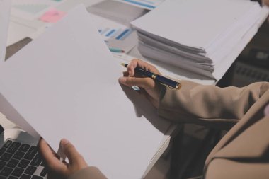 Tablet, akıllı telefon ve dizüstü bilgisayarlı iş belgeleri ve veri tartışan iki iş arkadaşı