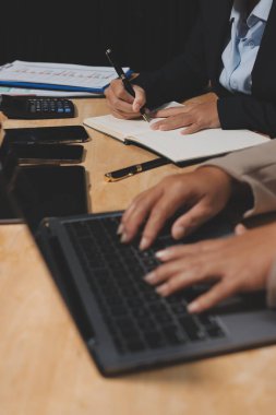 Muhasebe şirketi kazançlı nakit akışı için finansman ve vergilendirme planlaması, ofiste çalışan denetçi ve muhasebeci ekibi, mali verileri ve muhasebe kayıtlarını hesap makinesiyle analiz eder.