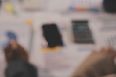 Tablet, akıllı telefon ve dizüstü bilgisayarlı iş belgeleri ve veri tartışan iki iş arkadaşı