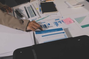 Tablet, akıllı telefon ve dizüstü bilgisayarlı iş belgeleri ve veri tartışan iki iş arkadaşı