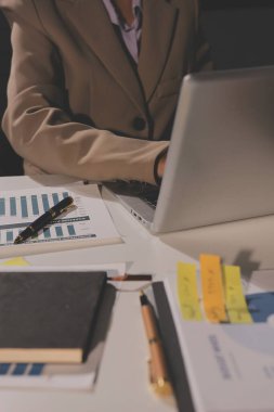 Tablet, akıllı telefon ve dizüstü bilgisayarlı iş belgeleri ve veri tartışan iki iş arkadaşı