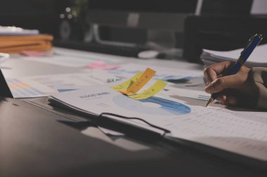 Tablet, akıllı telefon ve dizüstü bilgisayarlı iş belgeleri ve veri tartışan iki iş arkadaşı