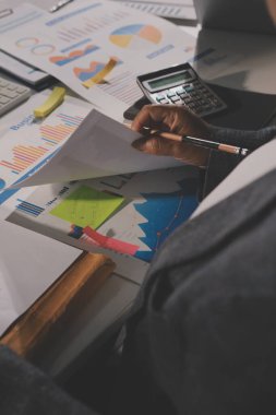 Tablet, akıllı telefon ve dizüstü bilgisayarlı iş belgeleri ve veri tartışan iki iş arkadaşı