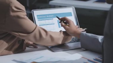 Ofiste çalışan iki ciddi iş adamı iş yerinde dizüstü bilgisayarlarıyla birlikte şirketin mali durumunu inceleyen bilgisayar monitörlerine bakıyor. Muhasebeci iş konsepti.