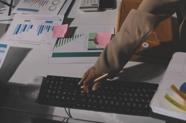 Tablet, akıllı telefon ve dizüstü bilgisayarlı iş belgeleri ve veri tartışan iki iş arkadaşı