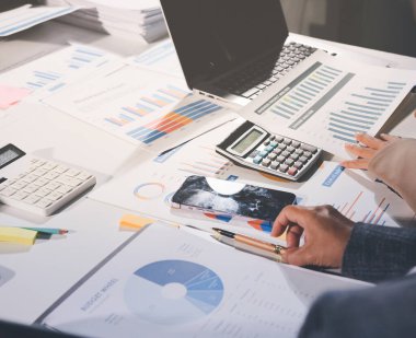 Tablet, akıllı telefon ve dizüstü bilgisayarlı iş belgeleri ve veri tartışan iki iş arkadaşı