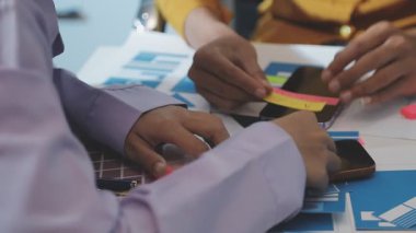 Uxui tasarımcılarından oluşan bir ekip bilgisayar ekranını işaret ederek ofiste yeni mobil uygulama tasarımını tartışıyor.