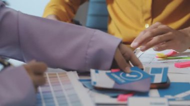 Uxui tasarımcılarından oluşan bir ekip bilgisayar ekranını işaret ederek ofiste yeni mobil uygulama tasarımını tartışıyor.