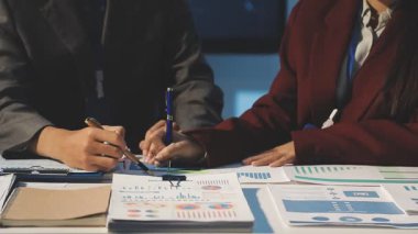 Milenyum Asyalı iş adamları ve iş kadınları yeni evrak projeleri hakkında fikir alışverişinde bulunuyorlar. İş arkadaşları birlikte çalışıyorlar. Başarı stratejisi planlıyorlar..