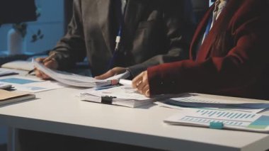 Milenyum Asyalı iş adamları ve iş kadınları yeni evrak projeleri hakkında fikir alışverişinde bulunuyorlar. İş arkadaşları birlikte çalışıyorlar. Başarı stratejisi planlıyorlar..