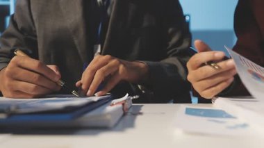 Milenyum Asyalı iş adamları ve iş kadınları yeni evrak projeleri hakkında fikir alışverişinde bulunuyorlar. İş arkadaşları birlikte çalışıyorlar. Başarı stratejisi planlıyorlar..