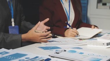 Milenyum Asyalı iş adamları ve iş kadınları yeni evrak projeleri hakkında fikir alışverişinde bulunuyorlar. İş arkadaşları birlikte çalışıyorlar. Başarı stratejisi planlıyorlar..