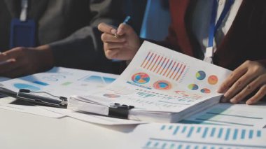 Milenyum Asyalı iş adamları ve iş kadınları yeni evrak projeleri hakkında fikir alışverişinde bulunuyorlar. İş arkadaşları birlikte çalışıyorlar. Başarı stratejisi planlıyorlar..