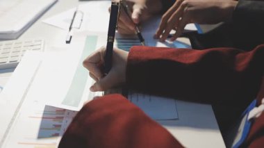 Milenyum Asyalı iş adamları ve iş kadınları yeni evrak projeleri hakkında fikir alışverişinde bulunuyorlar. İş arkadaşları birlikte çalışıyorlar. Başarı stratejisi planlıyorlar..