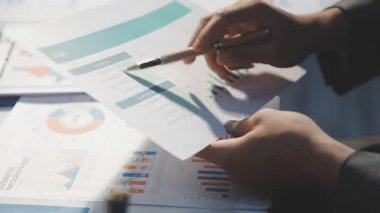 Milenyum Asyalı iş adamları ve iş kadınları yeni evrak projeleri hakkında fikir alışverişinde bulunuyorlar. İş arkadaşları birlikte çalışıyorlar. Başarı stratejisi planlıyorlar..