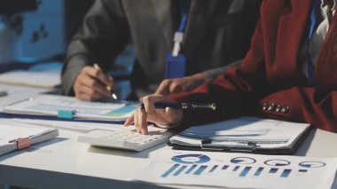 Milenyum Asyalı iş adamları ve iş kadınları yeni evrak projeleri hakkında fikir alışverişinde bulunuyorlar. İş arkadaşları birlikte çalışıyorlar. Başarı stratejisi planlıyorlar..