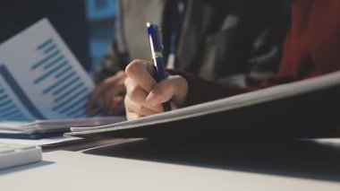 Milenyum Asyalı iş adamları ve iş kadınları yeni evrak projeleri hakkında fikir alışverişinde bulunuyorlar. İş arkadaşları birlikte çalışıyorlar. Başarı stratejisi planlıyorlar..