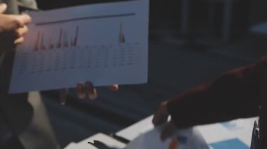 Milenyum Asyalı iş adamları ve iş kadınları yeni evrak projeleri hakkında fikir alışverişinde bulunuyorlar. İş arkadaşları birlikte çalışıyorlar. Başarı stratejisi planlıyorlar..