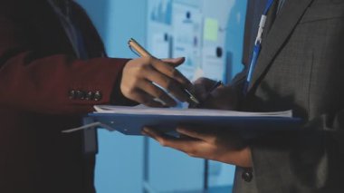 Milenyum Asyalı iş adamları ve iş kadınları yeni evrak projeleri hakkında fikir alışverişinde bulunuyorlar. İş arkadaşları birlikte çalışıyorlar. Başarı stratejisi planlıyorlar..