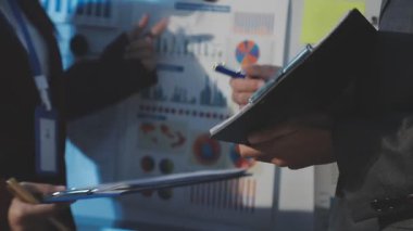 Milenyum Asyalı iş adamları ve iş kadınları yeni evrak projeleri hakkında fikir alışverişinde bulunuyorlar. İş arkadaşları birlikte çalışıyorlar. Başarı stratejisi planlıyorlar..