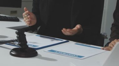 Adalet ve hukuk kavramı. Gavel, mahkeme salonundaki erkek hakim hakkında, evrak hukuku kitaplarıyla çalışıyor, davayı modern bürodaki masada rapor ediyor..