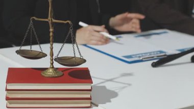 Adalet ve hukuk kavramı. Gavel, mahkeme salonundaki erkek hakim hakkında, evrak hukuku kitaplarıyla çalışıyor, davayı modern bürodaki masada rapor ediyor..