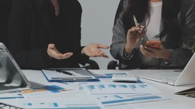 Professional accountants working in a well lit office, analyzing financial data and reviewing statements with a calculator and pen. Audit and taxes theme in business