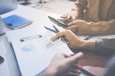 Muhasebe şirketi karlı nakit akışı için finansman ve vergilendirme planlaması, ofiste çalışan muhasebeci, mali verileri ve muhasebe kayıtlarını hesap makinesiyle analiz eder