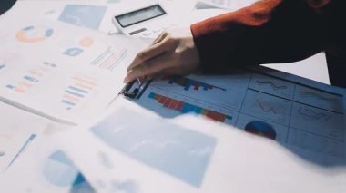 Bir grup menajer iş saatinden sonra akşam saatlerinde takım toplantısı yapıyor. Meslektaşlar Yıllık Finansal ve Pazarlama Raporlarını Tartışıyor. Yaratıcı Ofis 'te takım çalışması. Eller Üzerinde Kapat.