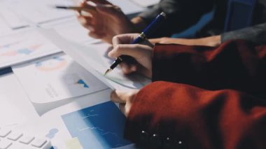 Bir grup menajer iş saatinden sonra akşam saatlerinde takım toplantısı yapıyor. Meslektaşlar Yıllık Finansal ve Pazarlama Raporlarını Tartışıyor. Yaratıcı Ofis 'te takım çalışması. Eller Üzerinde Kapat.