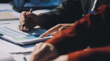 Bir grup menajer iş saatinden sonra akşam saatlerinde takım toplantısı yapıyor. Meslektaşlar Yıllık Finansal ve Pazarlama Raporlarını Tartışıyor. Yaratıcı Ofis 'te takım çalışması. Eller Üzerinde Kapat.