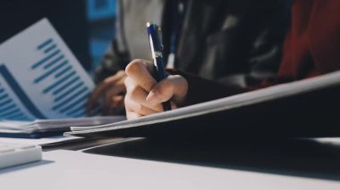 Bir grup menajer iş saatinden sonra akşam saatlerinde takım toplantısı yapıyor. Meslektaşlar Yıllık Finansal ve Pazarlama Raporlarını Tartışıyor. Yaratıcı Ofis 'te takım çalışması. Eller Üzerinde Kapat.